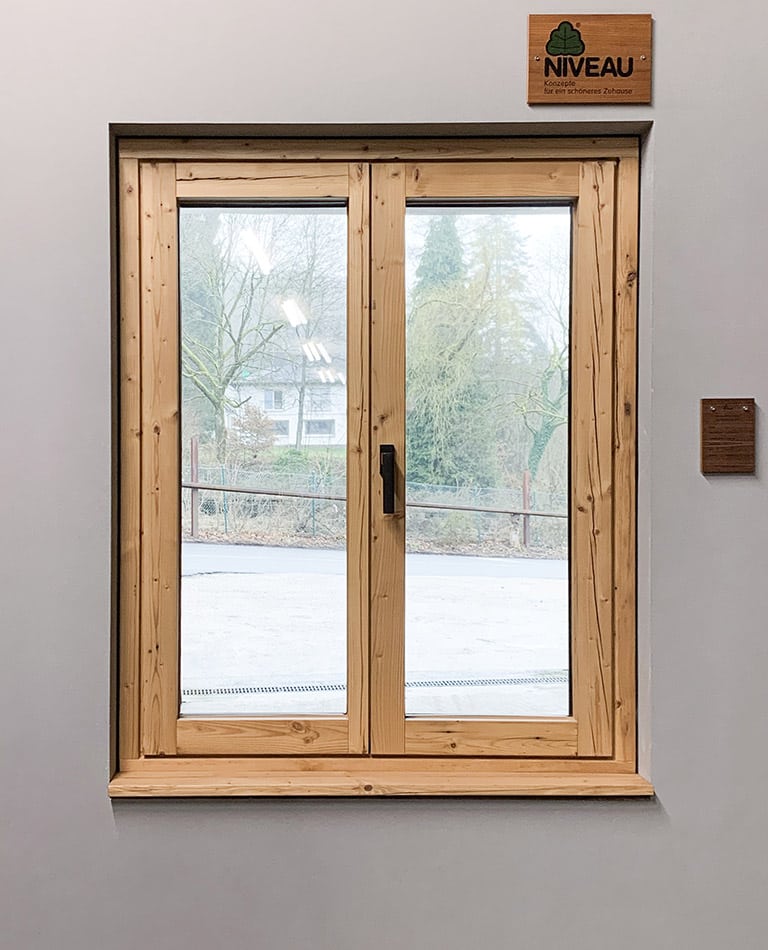 Ein Holzfenster mit Blick nach draußen.