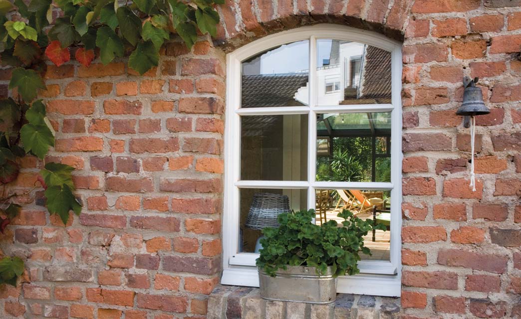 Ein oben abgerundetes Fenster mit Sprossen.